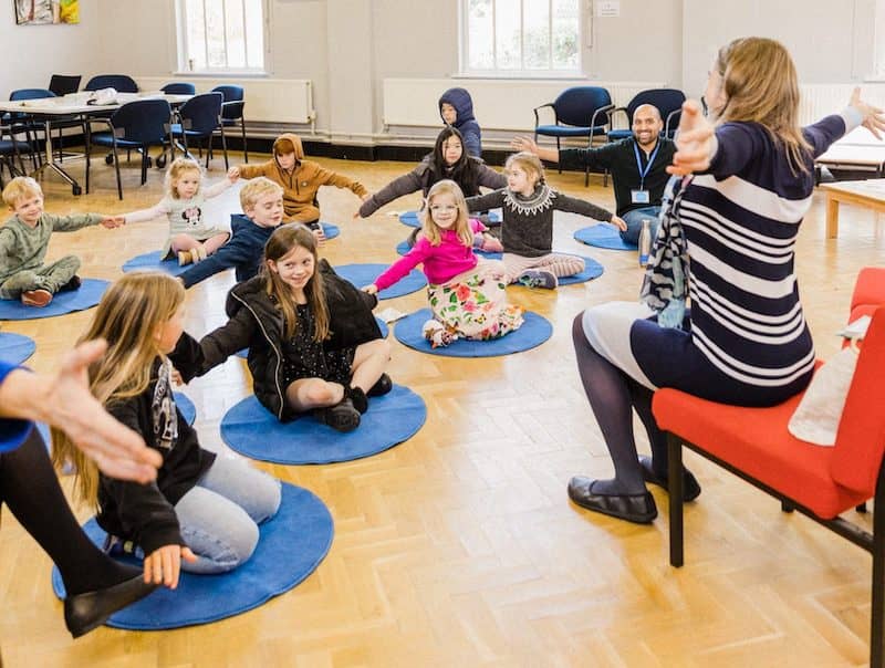 Primary school age children playing doing actions while singing